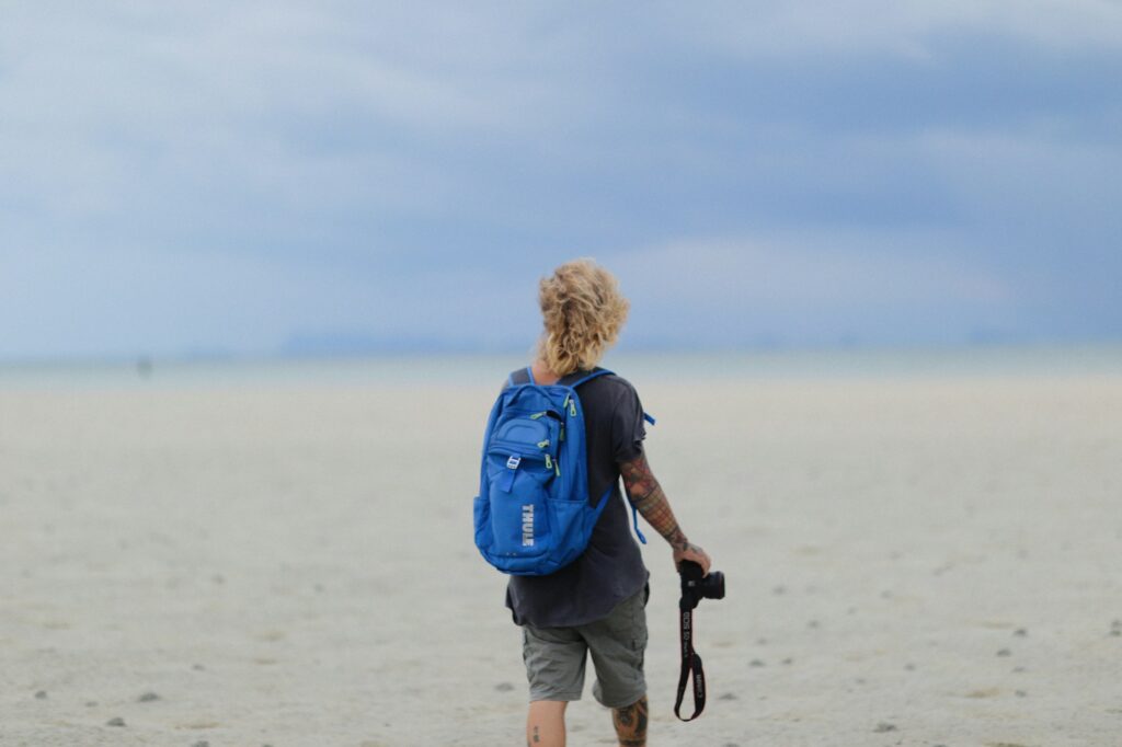 a person with a blue backpack and a camera
